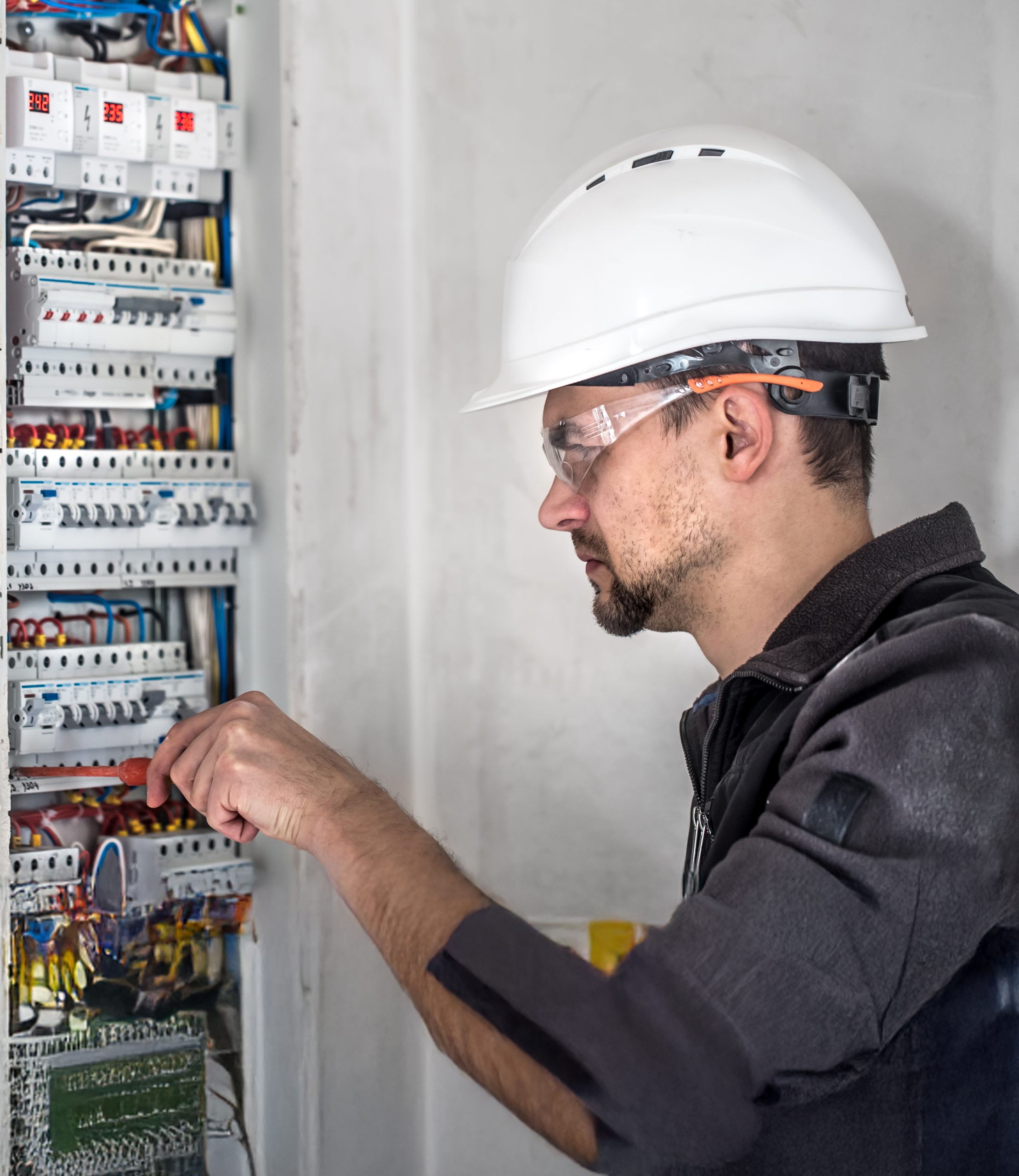Man, an electrical technician working in a switchboard with fuses. Installation and connection of electrical equipment. Foro Regional Aciem Seccional Cundinamarca: ¿Cuáles Deben Ser Las Apuestas De Bogotá En Electrónica Y Semiconductores?